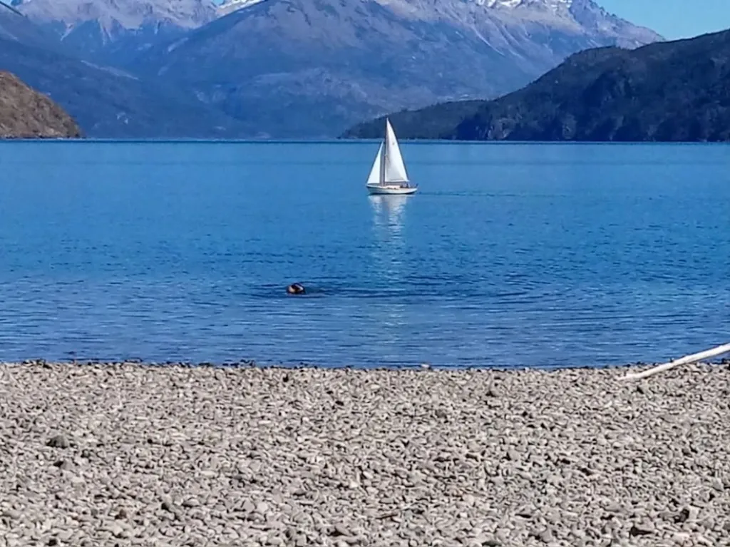 Velero en el Lago Puelo con montañas al fondo